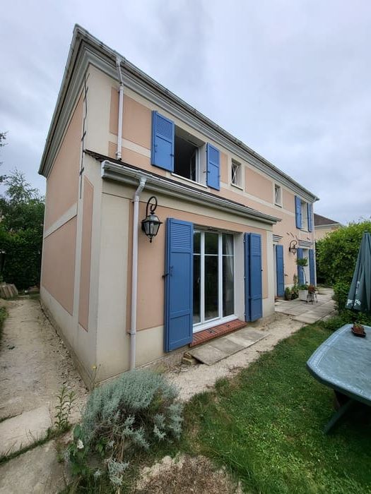 Maison roses avec volets bleus