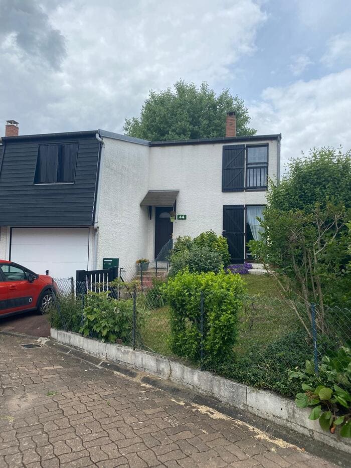Maison à volets noirs avec jardin