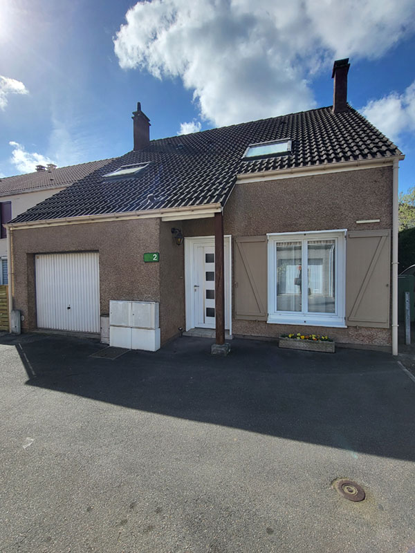 Façade maison avec porte de garage, porte d'entrée et fenêtre avec volets ouverts